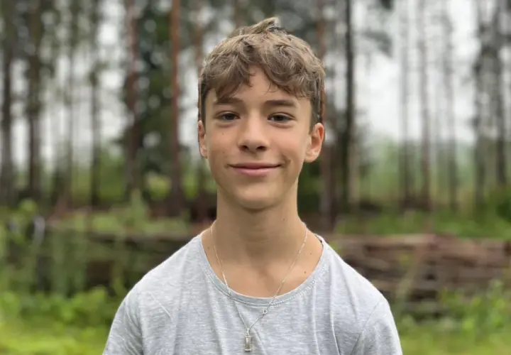 En leende Jack Bergnorth Henriksson står framför en skog.