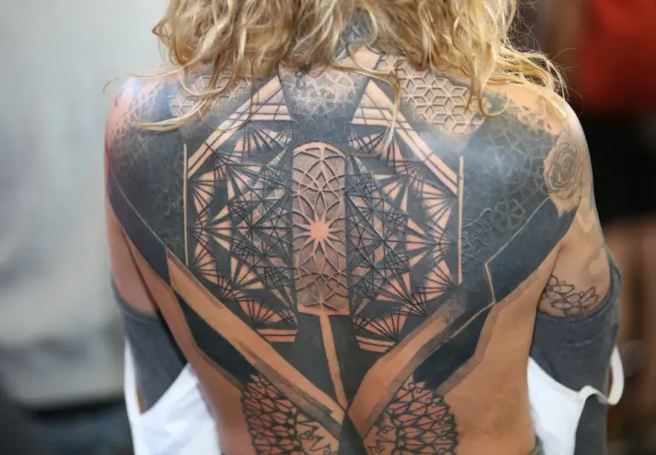 Niesamowity tatuaż 3d na plecach, pełen geometrycznych wzorów i cieniowania, tworzący iluzję głębi.
