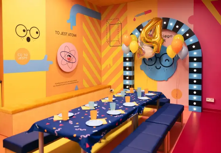 Urodzinowa sala w Smart Kids Planet Warszawa. Kolorowe ściany, balony i stół gotowy na przyjęcie małych odkrywców.