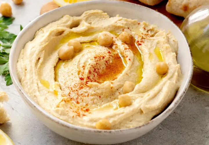 Hummus cremoso, con garbanzos, pimentón y aceite de oliva. Una deliciosa hummus receta tradicional, lista para disfrutar con pan.
