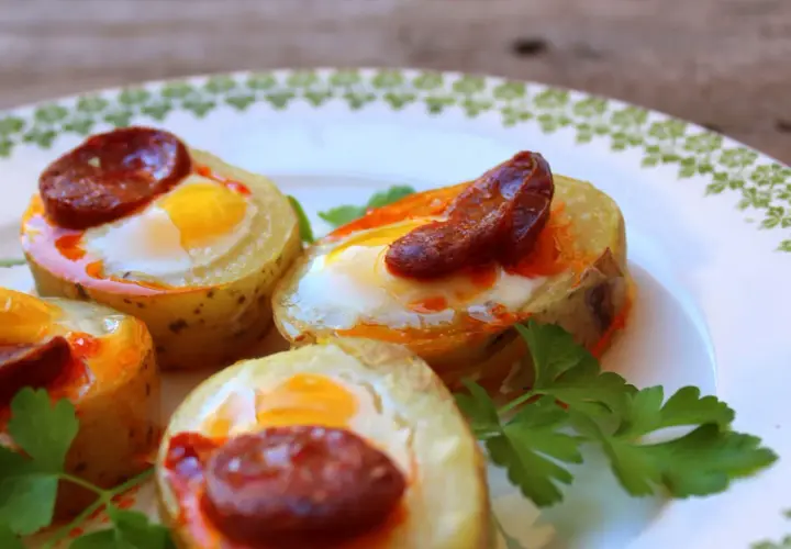 Canapés con huevo de codorniz y chorizo, horneados en rodajas de patata. Un bocado delicioso y original.