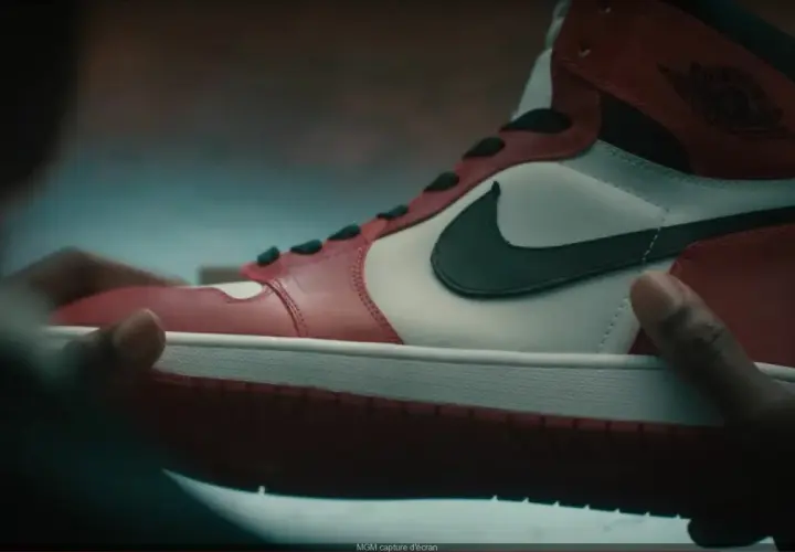 Dłonie trzymają kultowe czerwono-białe buty Air Jordan 1. Ten się śmieje, kto ma zęby, a te buty to marzenie wielu.