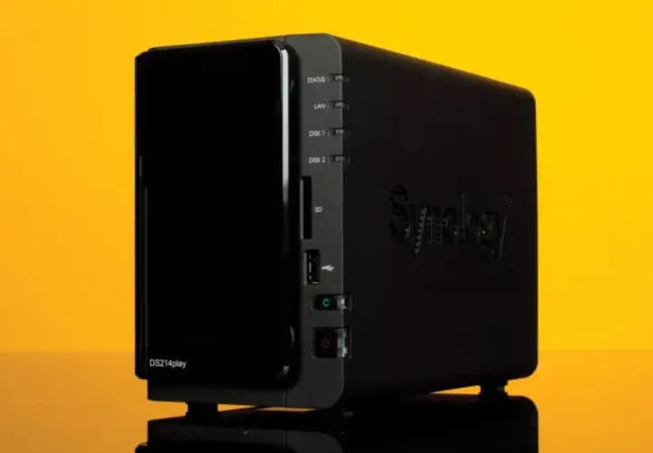 Un dispositivo Synology DS214play, que es un NAS, con luces indicadoras y puertos.