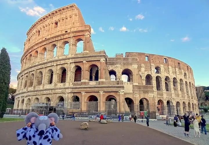 Un éléphant en peluche devant le Colisée. On se demande si peut on visiter le Colisée sans réservation, mais ce petit visiteur semble prêt à explorer !