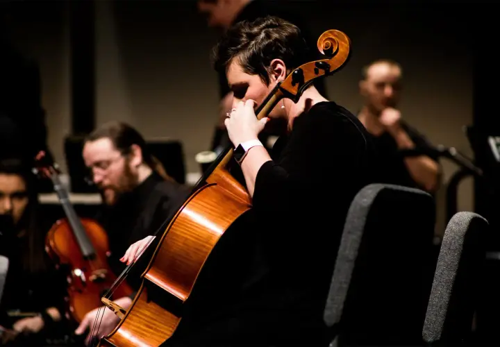 Une musicienne joue du contrebasse dans un orchestre.