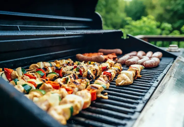 Brochettes de poulet et légumes, saucisses en train de griller sur un barbecue, parfait pour une soirée barbecue d'été.