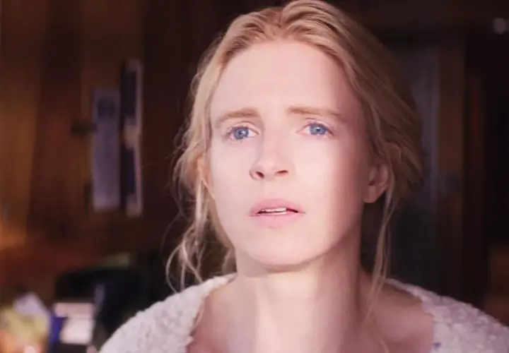 Le visage d'une femme blonde aux yeux bleus, l'air préoccupé, dans la happy série saison 3.