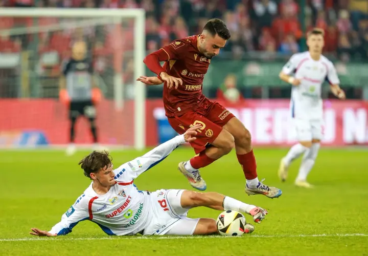 Piłkarz Widzewa Łódź walczy o piłkę z zawodnikiem Górnika Zabrze. Intensywna akcja na boisku.
