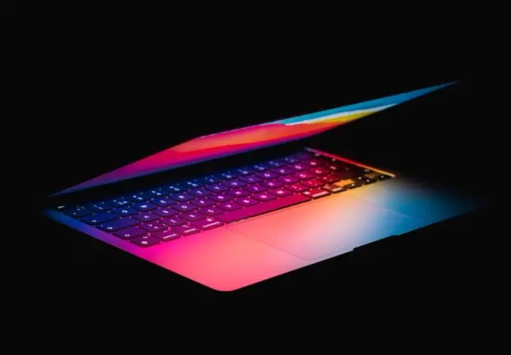 Kolorowy laptop, idealny do pracy w Photoshopie, z podświetlaną klawiaturą w odcieniach tęczy.