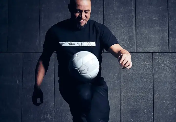 Roberto Carlos żyje i wciąż czaruje piłką! Legenda futbolu w czarnej koszulce z przesłaniem "LOVE YOUR NEIGHBOUR" bawi się białym futbolem.