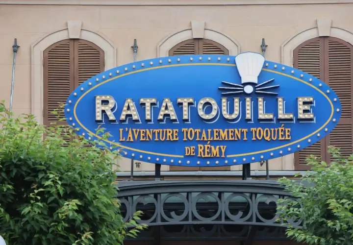 Panneau bleu lumineux de Ratatouille, l'aventure totalement toquée de Rémy, devant un bâtiment.