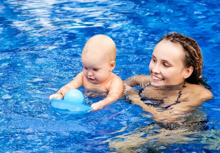 Mama z niemowlakiem w basenie. Po kąpieli można wyjść na dwór z niemowlakiem, gdy jest ciepło i dziecko jest dobrze osuszone.
