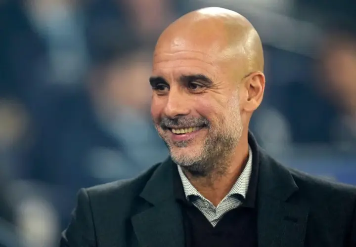 Uśmiechnięty Pep Guardiola, trener Manchesteru City, omawia najnowsze manchester city transfery.