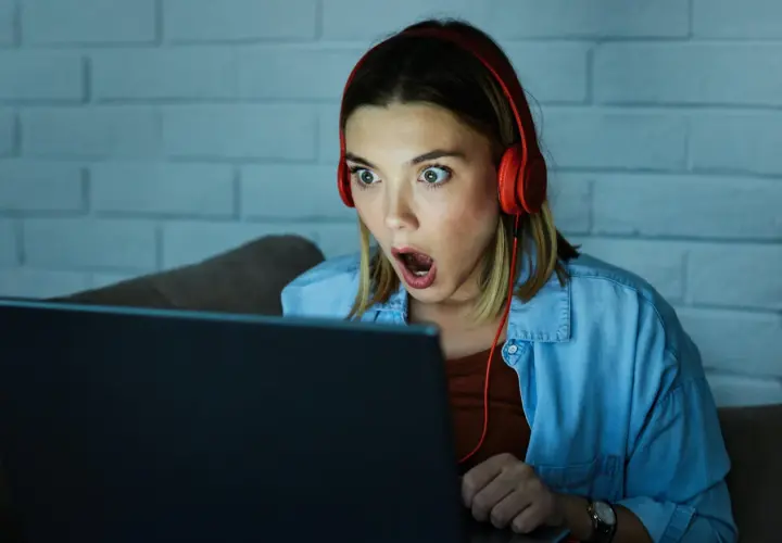 Zaskoczona dziewczyna w słuchawkach gra w escape gry online.