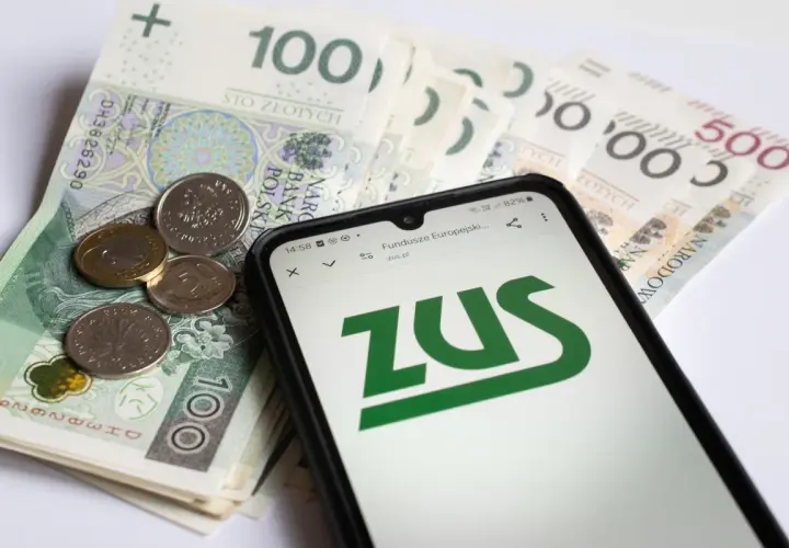 Pieniądze i telefon z logo ZUS. Ojciec planuje urlop rodzicielski, sprawdza świadczenia.