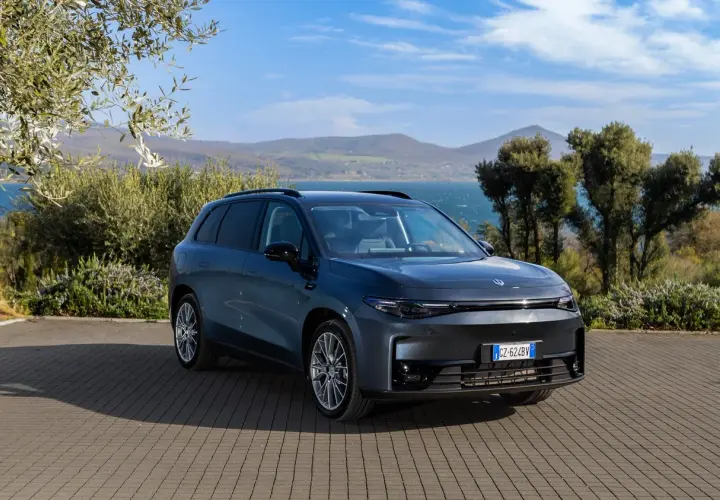 Leapmotor B10 REEV, un SUV elettrico dal design moderno, parcheggiato su un selciato con vista su un lago e colline verdi.