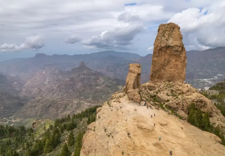 Majestatyczne skały Roque Nublo na Gran Canaria, z turystami podziwiającymi krajobraz.