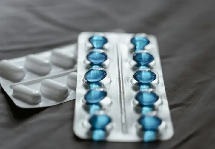 Dwa blistry leków: jeden z białymi kapsułkami, drugi z niebieskimi, prawdopodobnie pregabalin zentiva.