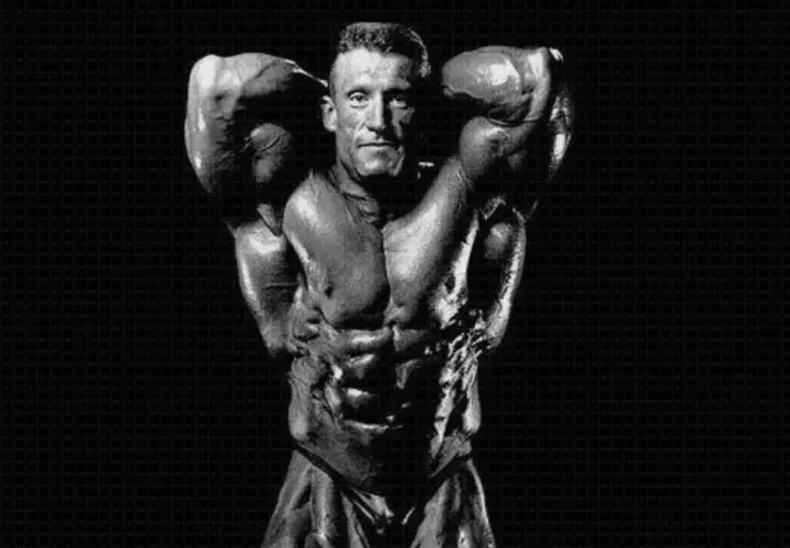 Dorian Yates prezentuje imponującą muskulaturę, dowód ciężkiego treningu.
