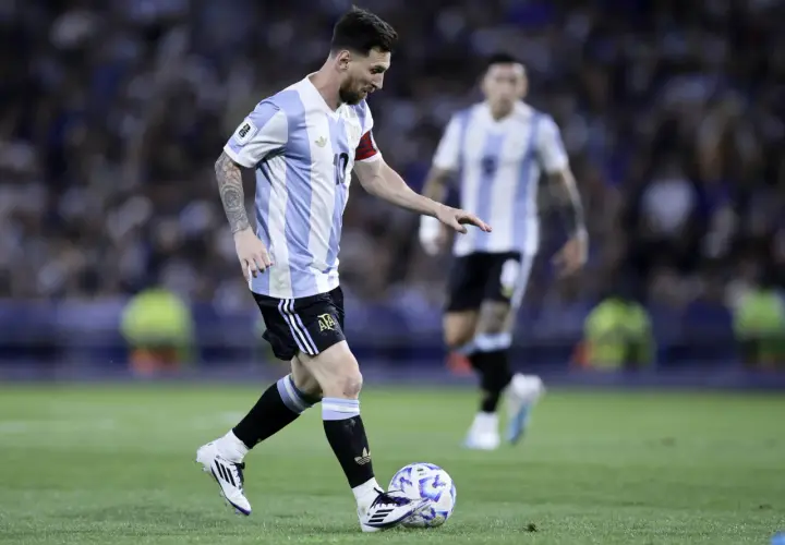 Lionel Messi w koszulce Argentyny prowadzi piłkę. Jego wzrost nie przeszkadza mu w byciu jednym z najlepszych piłkarzy świata.