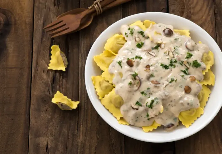 Ravioli z grzybami w sosie śmietana kremówka, posypane natką pietruszki.
