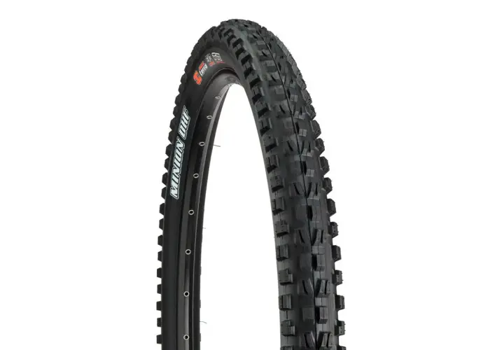 A close-up of a Maxxis Minion DHF tire, ready for a downhill review. Its aggressive tread promises grip.