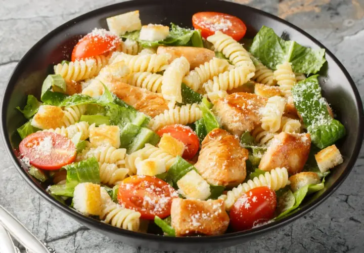 Prosta sałatka z piersią kurczaka, makaronem fusilli, pomidorkami koktajlowymi, grzankami i parmezanem.