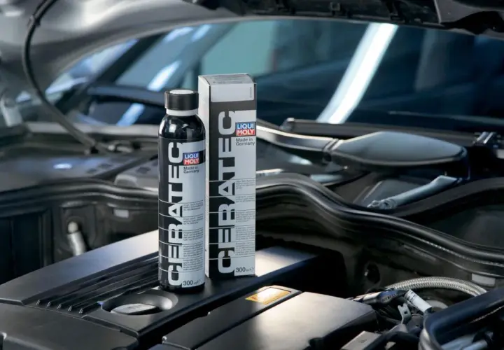Botella y caja de LIQUI MOLY Cera Tec en un motor. Evita problemas de motor con este aditivo cerámico.