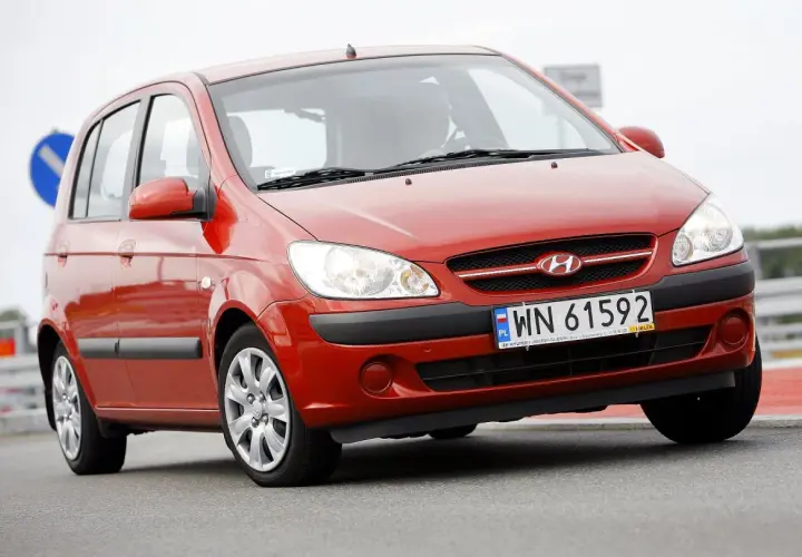 Czerwony Hyundai Getz 1.1 z polskimi tablicami WN 61592 na drodze.