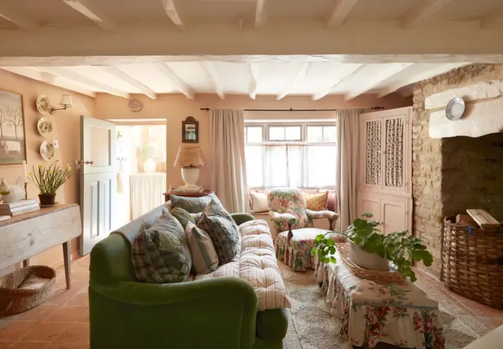 A cozy living room with a green sofa, floral armchair, and a bench, all embodying a charming modern grandma style.