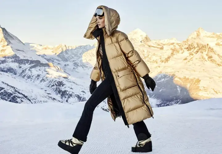 Modelka w złotej kurtce i goglach narciarskich, gotowa na après-ski w górach.