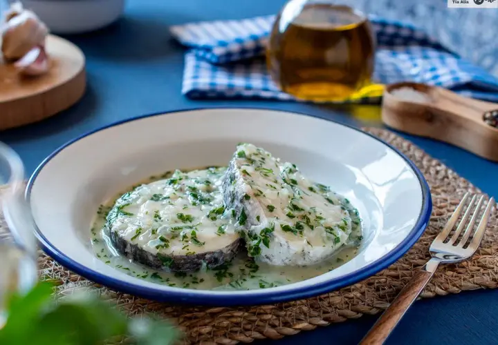 Dos rodajas de merluza en salsa verde, con perejil picado y un toque de ajo.