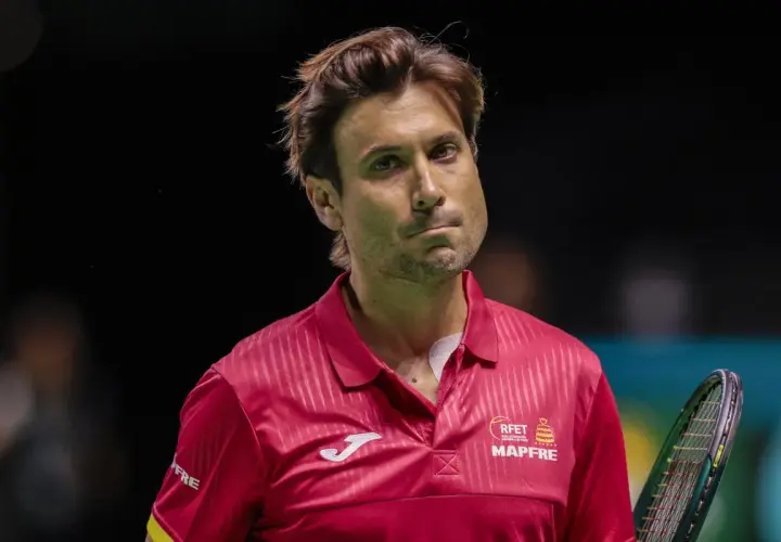 David Ferrer, tenisista w czerwonej koszulce, zamyślony na korcie.