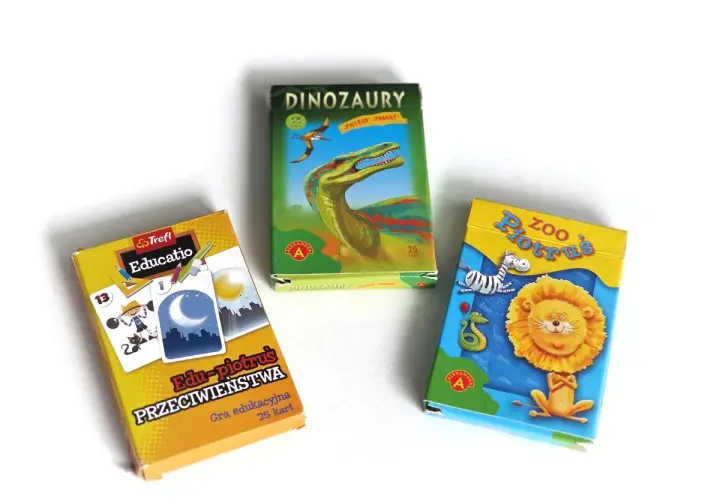 Trzy pudełka gier karcianych: "Edu-piotruś Przeciwieństwa", "Dinozaury Piotruś Pamięć" i "Zoo Piotruś". Idealne do nauki i zabawy, jak się gra w piotrusia.
