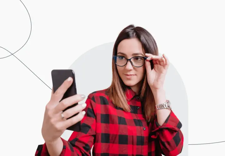 Kobieta w okularach robi selfie telefonem, zastanawiając się, czy do dowodu można mieć zdjęcie w okularach.
