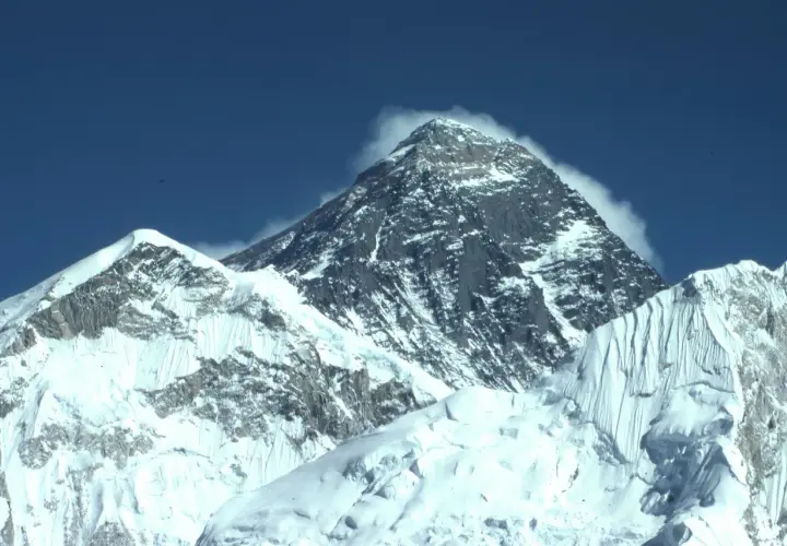 Majestatyczne szczyty pokryte śniegiem, chmury otulające wierzchołek. Widok zapierający dech w piersiach, symbol wejścia na Mount Everest.