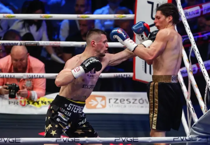 Dwóch bokserów walczy na ringu podczas babilon boxing show. Jeden z nich wyprowadza cios.