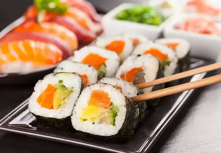 Zestaw sushi z łososiem i warzywami, podany z pałeczkami. Czy sushi to fast food? To pytanie, na które odpowiedź zależy od sposobu przygotowania.