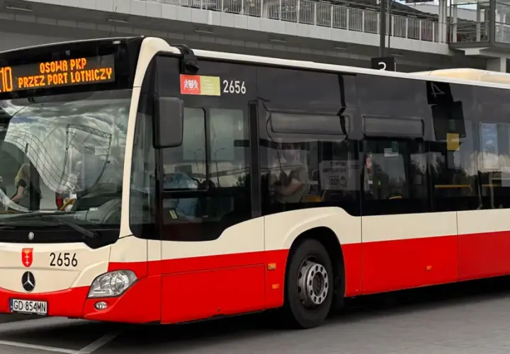 Autobus linii 210 "Przez Port Lotniczy" czeka na pasażerów na przystanku.