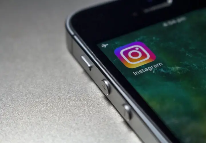 Zbliżenie na ekran telefonu z ikoną Instagrama. Czy widac screeny relacji na IG?