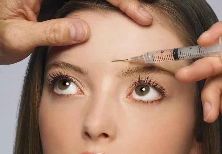 Nahaufnahme einer Frau, der Botox in die Stirn injiziert wird. Mögliche botox spätfolgen im Blick.
