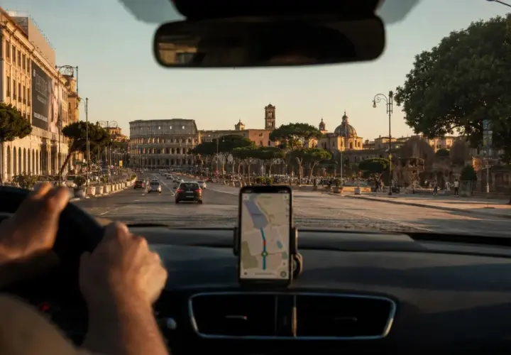 Navigatore in auto indica la strada per la stazione metro Anagnina, con il Colosseo sullo sfondo.