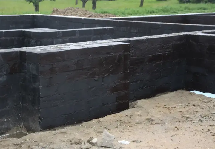 Fundament z czarnej cegły, przygotowany do dalszych prac. Widać, że próbowano go disprobit, by zabezpieczyć przed wilgocią.