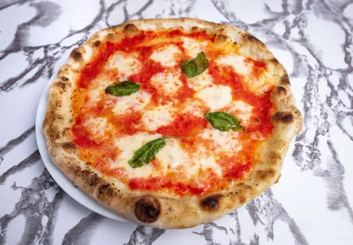 Pyszna pizza neapolitańska z pomidorami, mozzarellą i bazylią. Zastanawiasz się, ile kalorii ma pizza neapolitanska?