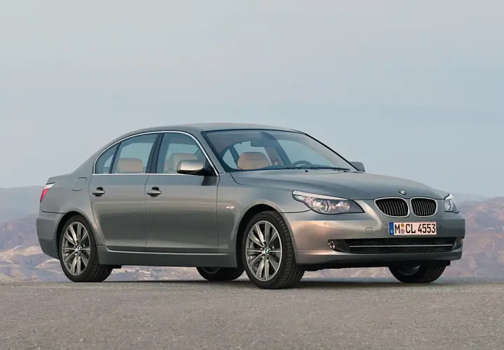 Szary sedan BMW 535d na tle górskiego krajobrazu.