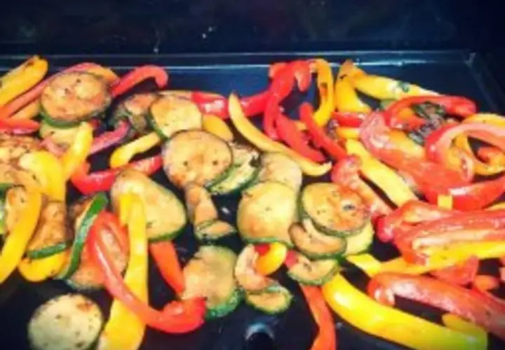 Légumes à la plancha marinés : poivrons rouges et jaunes coupés en lanières, courgettes rondes grillées. Un délice coloré !