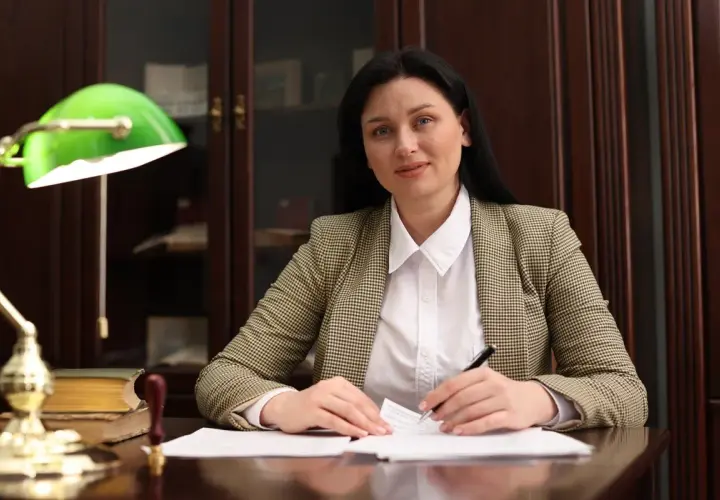 Kobieta w biurze analizuje dokumenty, zastanawiając się, ile zarabiają adwokaci.