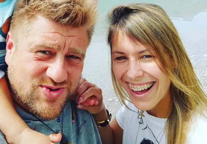 Tomasz Jakubiak z żoną i dzieckiem na wakacjach. Uśmiechnięta para cieszy się wspólnym czasem.