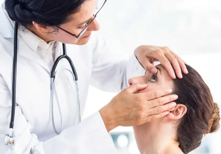 Lekarka bada pacjentkę, która skarży się na mroczki przed oczami.