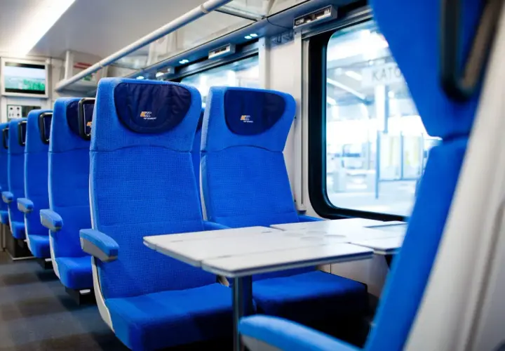 Wygodne, niebieskie siedzenia w przedziale konduktorskim PKP Intercity. Czekają na pasażerów, by zabrać ich w podróż.